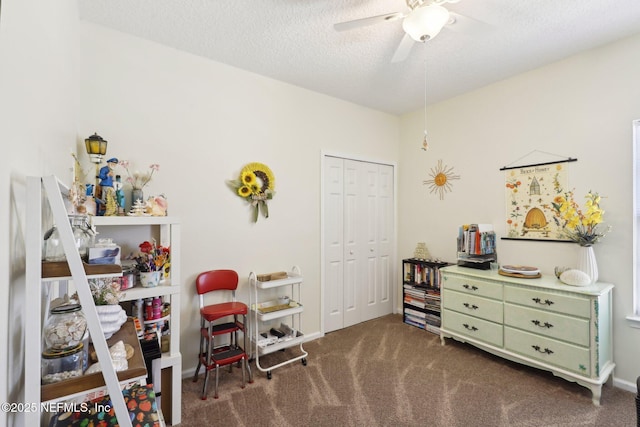 recreation room featuring carpet flooring, a textured ceiling, and a ceiling fan