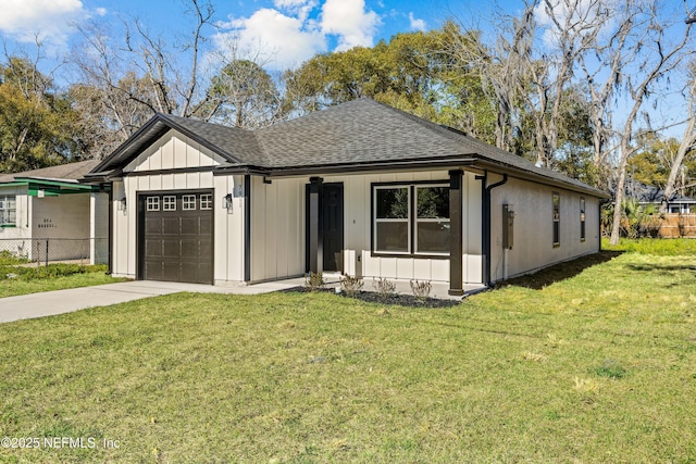 view of front of house featuring board and batten siding, fence, a front yard, roof with shingles, and an attached garage