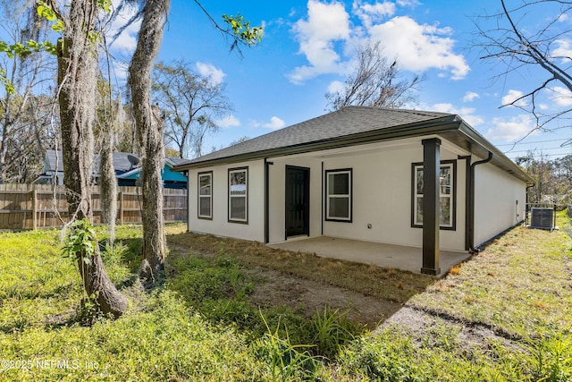 back of property featuring a patio, central AC unit, fence, and stucco siding