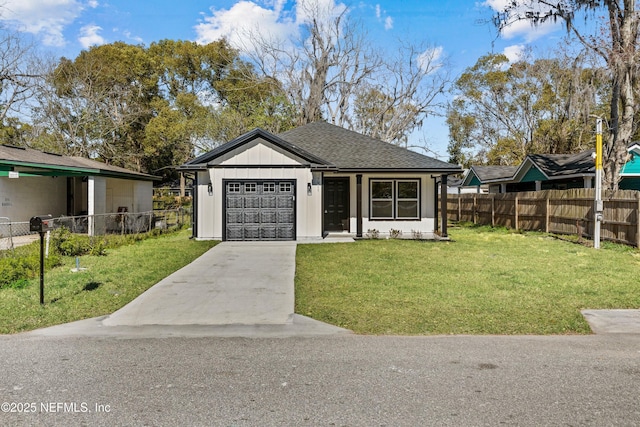 view of front of property featuring driveway, a front yard, a garage, and fence