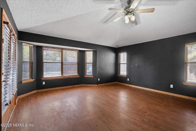 unfurnished room with baseboards, wood finished floors, and vaulted ceiling