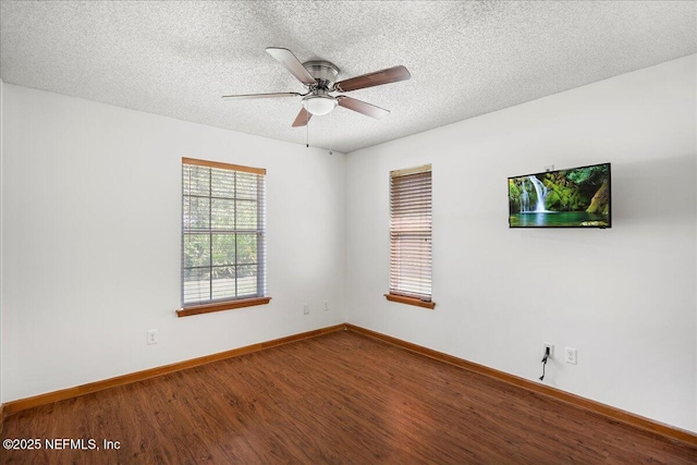 empty room with a ceiling fan, wood finished floors, baseboards, and a textured ceiling