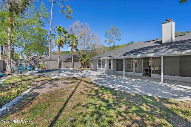 view of yard featuring a patio area, a fenced backyard, and a sunroom