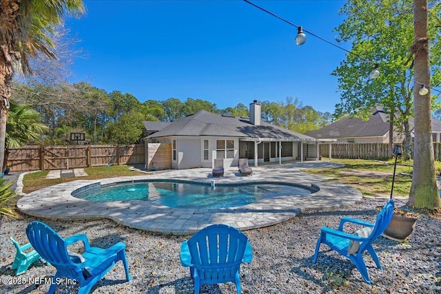 view of pool featuring a patio area, a fenced in pool, a fenced backyard, and a sunroom