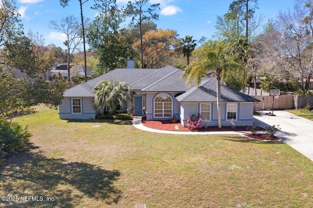 view of front of property with a front lawn, fence, and stucco siding