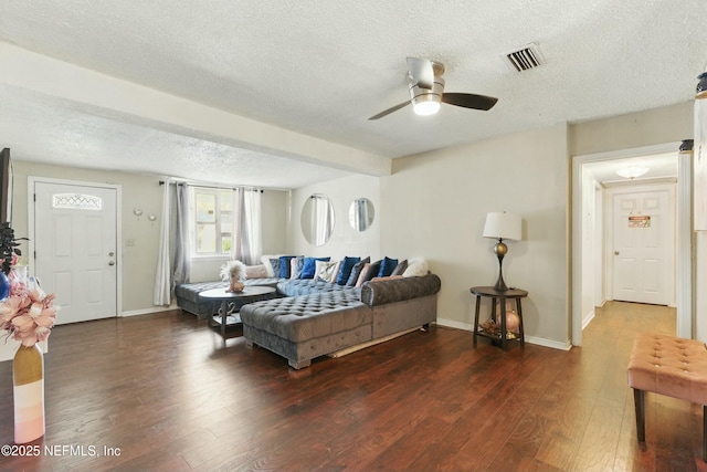 living area featuring visible vents, a textured ceiling, baseboards, and wood finished floors