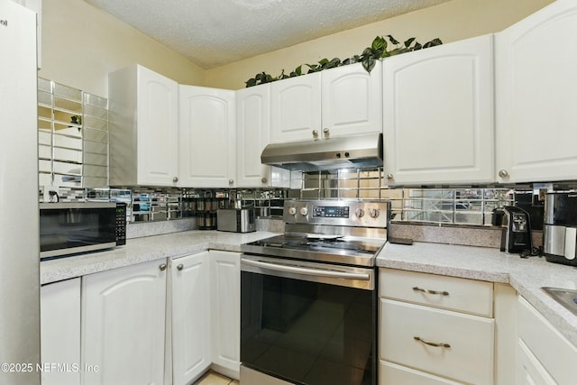 kitchen featuring under cabinet range hood, a textured ceiling, appliances with stainless steel finishes, white cabinets, and decorative backsplash