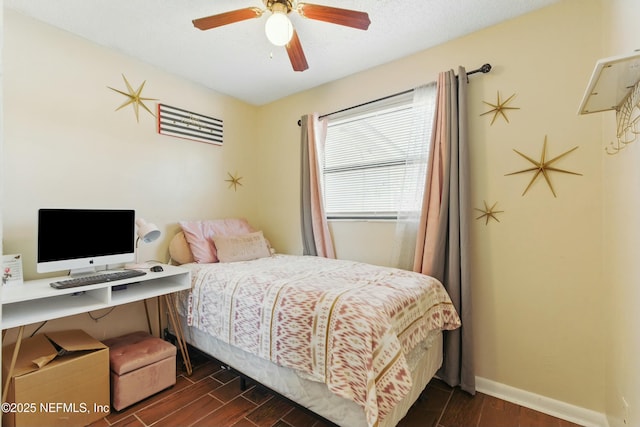 bedroom with a textured ceiling, a ceiling fan, baseboards, and wood tiled floor