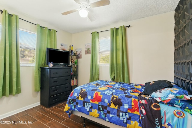 bedroom featuring wood finish floors, baseboards, a textured ceiling, and a ceiling fan