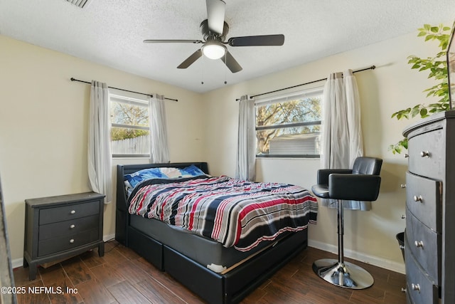 bedroom featuring ceiling fan, baseboards, a textured ceiling, and wood finished floors