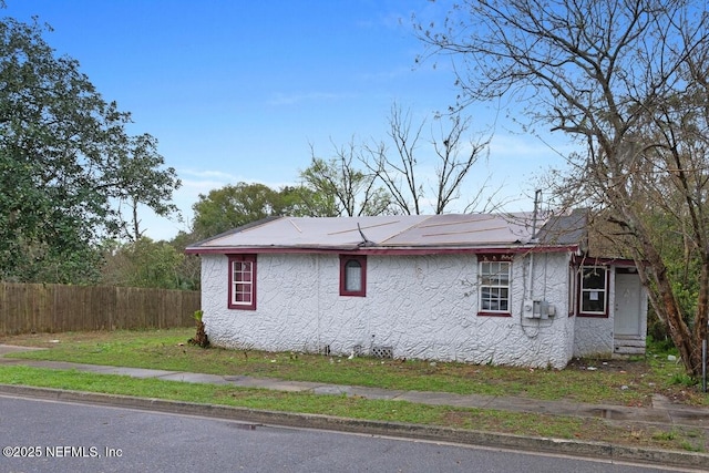 view of side of home featuring crawl space, stucco siding, and fence