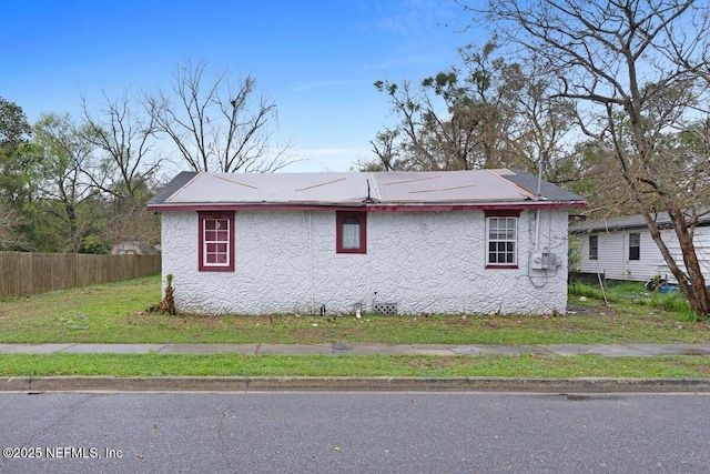 view of home's exterior with fence and stucco siding