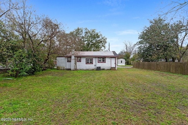 view of front facade with central air condition unit, a front lawn, and fence