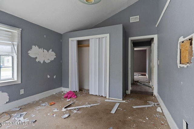 unfurnished bedroom featuring visible vents, lofted ceiling, baseboards, and a closet