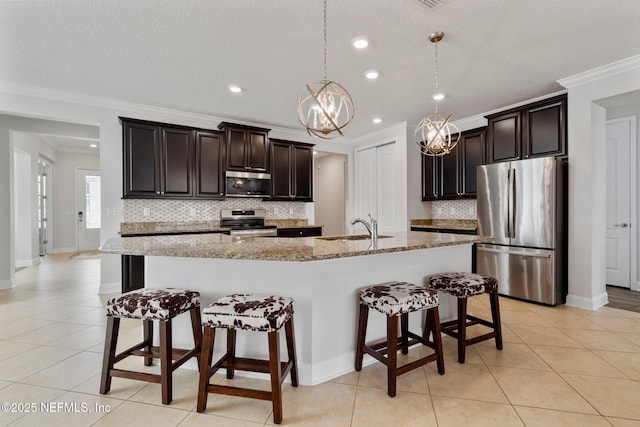 kitchen with a breakfast bar area, light tile patterned flooring, a sink, stainless steel appliances, and a notable chandelier