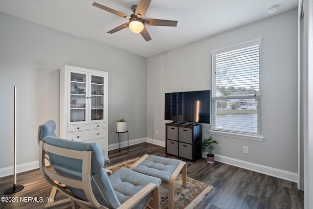 living area featuring baseboards, ceiling fan, and wood finished floors