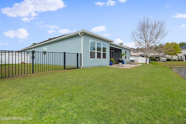 rear view of house with a patio area, stucco siding, a yard, and fence