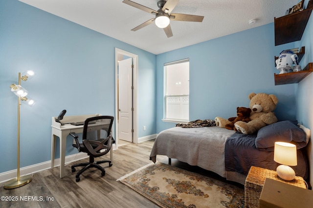 bedroom with baseboards, ceiling fan, and light wood finished floors