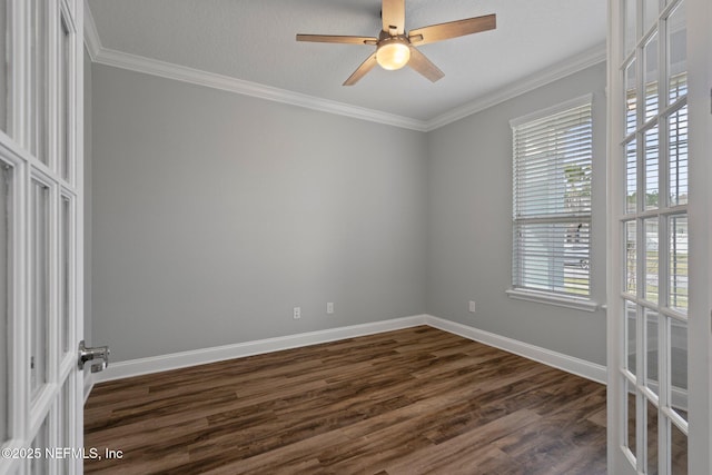 spare room with baseboards, ceiling fan, dark wood-style flooring, and crown molding