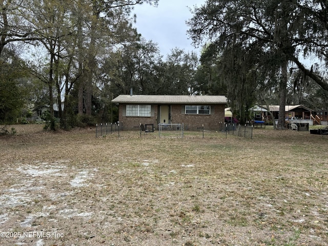 view of front facade with fence and brick siding