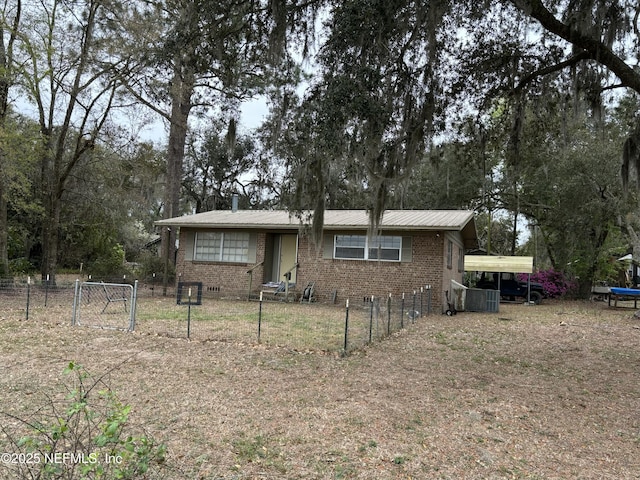 view of front facade with crawl space, fence, brick siding, and metal roof