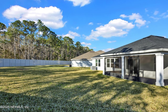 view of yard featuring central AC, fence, and a sunroom