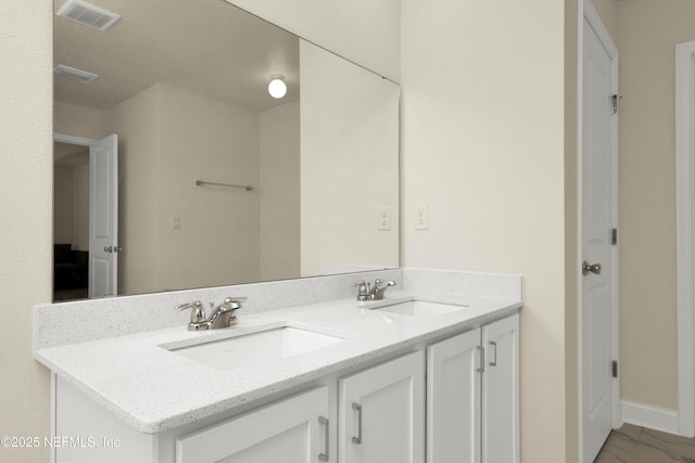 bathroom featuring double vanity, visible vents, marble finish floor, and a sink