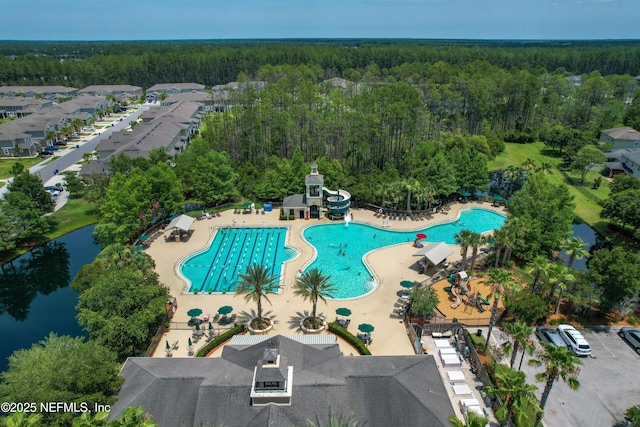 drone / aerial view featuring a view of trees and a water view