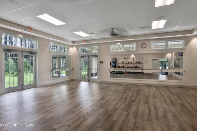 exercise area with visible vents, ceiling fan, baseboards, and wood finished floors