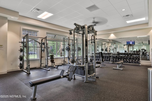 workout area featuring a paneled ceiling, visible vents, and baseboards