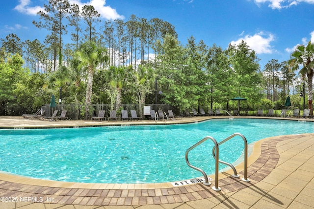 pool with a patio and fence