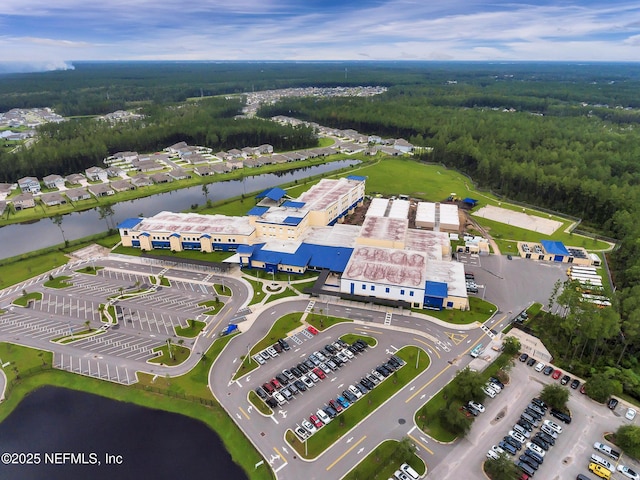 birds eye view of property featuring a forest view and a water view