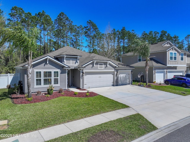 view of front of house with a front yard, concrete driveway, a garage, and fence