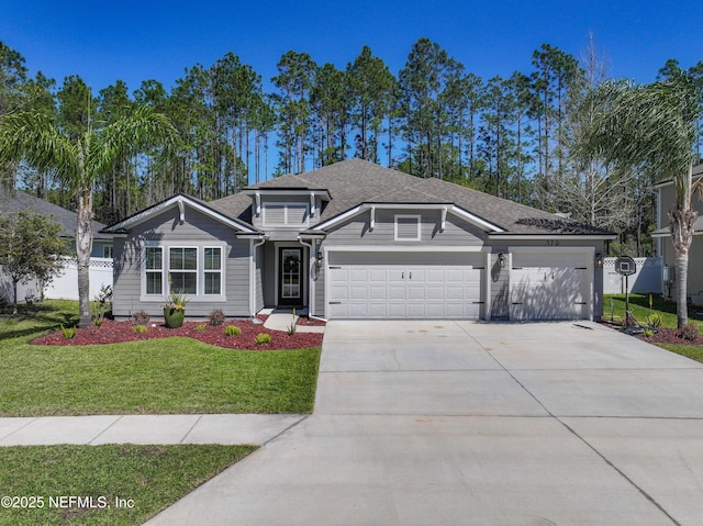 view of front facade with driveway, a front yard, an attached garage, and fence