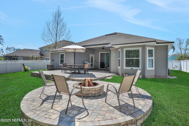 back of house with a patio, a fenced backyard, stucco siding, a fire pit, and a lawn