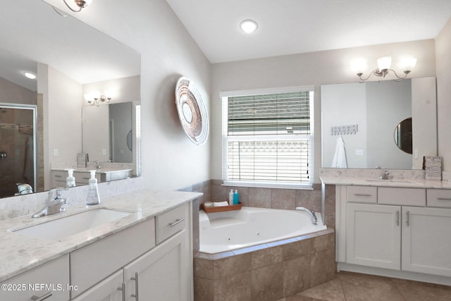 bathroom featuring tile patterned floors, a stall shower, a jetted tub, and a sink