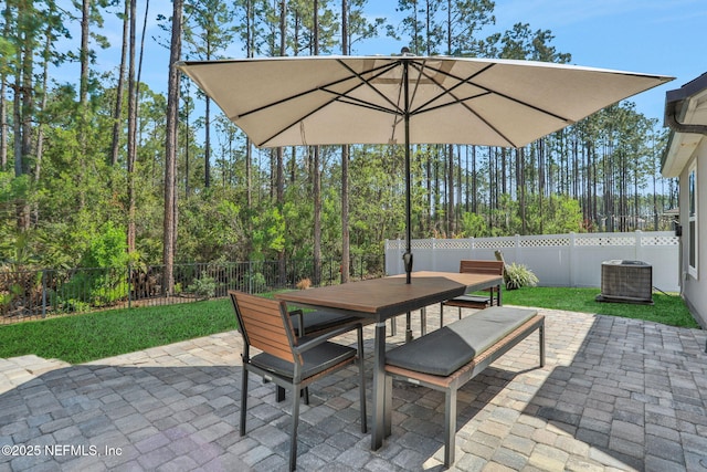 view of patio with outdoor dining area, central AC, and a fenced backyard