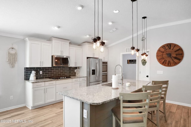 kitchen featuring a sink, crown molding, backsplash, and stainless steel appliances