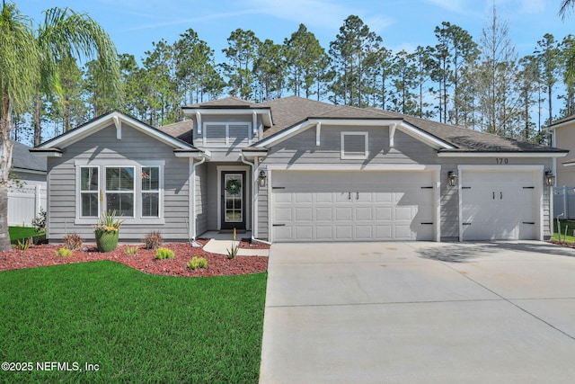 view of front of property featuring driveway, a front lawn, a garage, and fence