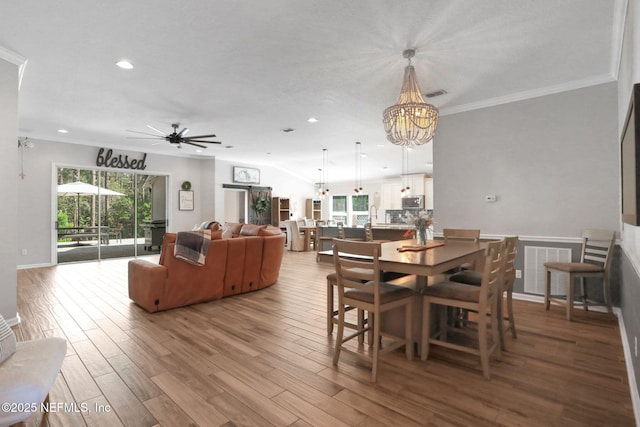 dining room featuring visible vents, a healthy amount of sunlight, wood finished floors, and crown molding