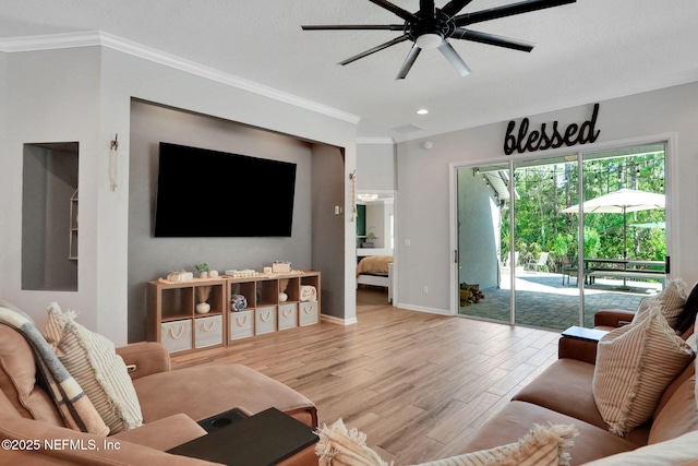 living area featuring baseboards, crown molding, ceiling fan, and wood finished floors