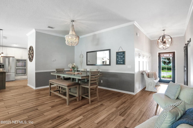 dining area featuring baseboards, light wood-style floors, an inviting chandelier, and ornamental molding