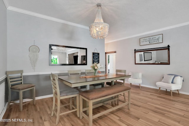 dining room featuring a chandelier, wood finished floors, baseboards, and ornamental molding