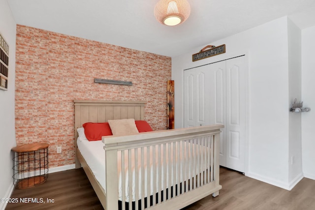 bedroom featuring a closet, baseboards, and wood finished floors