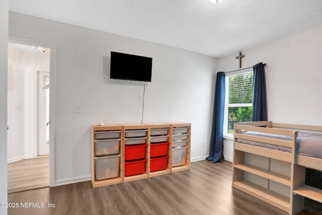 bedroom featuring wood finished floors and baseboards