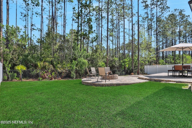 view of yard featuring a patio area, a fire pit, and fence