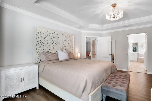 bedroom featuring an inviting chandelier, ornamental molding, a tray ceiling, and wood finished floors