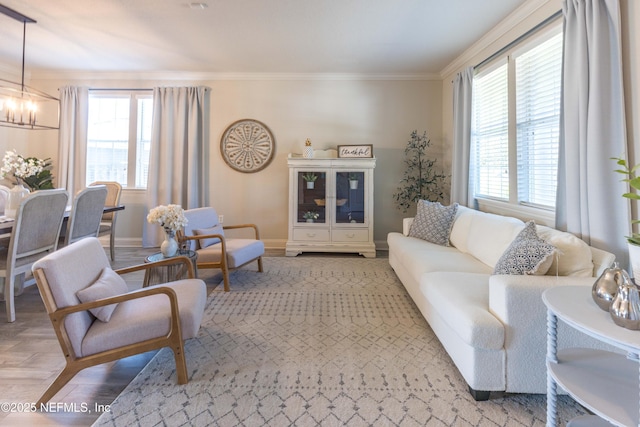 living area featuring a wealth of natural light, a notable chandelier, crown molding, and light wood finished floors