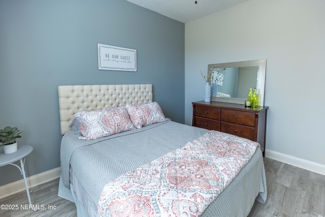 bedroom featuring wood finished floors and baseboards