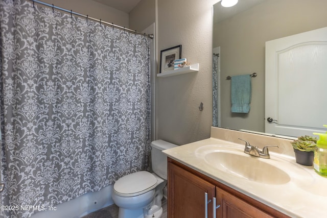 bathroom with curtained shower, toilet, vanity, and a textured wall